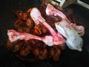 翻炒均匀后，炒出酱的香味，放入鸡骨，香料包