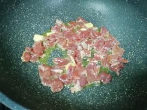 炒锅内倒适量的食用油烧热，下入腌好的牛肉片。