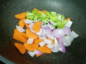 锅底留余油，下入胡萝卜洋葱青椒片翻炒均匀。