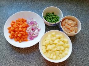 准备好食材，鸡脯肉洗干净切成小块，土豆去皮洗干净切成小块用水泡上，洋葱胡萝卜洗干净切成小块，青豆准备好。 大米淘好将米饭蒸上。