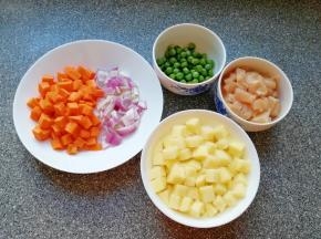 准备好食材，鸡脯肉洗干净切成小块，土豆去皮洗干净切成小块用水泡上，洋葱胡萝卜洗干净切成小块，青豆准备好。 大米淘好将米饭蒸上。