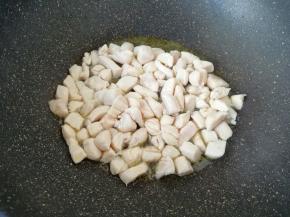 炒锅烧热倒入适量的食用油，下入腌好的鸡脯肉翻炒至变色。