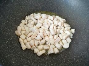 炒锅烧热倒入适量的食用油，下入腌好的鸡脯肉翻炒至变色。