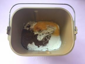 面包桶内加入高筋面粉、全蛋液、细砂糖、可可粉跟酵母；
