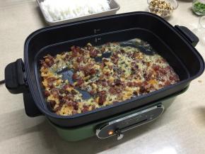 5.不粘炒锅内加入适量的玉米油，放入腊肠粒和腊肉粒爆炒至颜色变透，随后放入沥水后的虾米