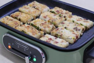 12.在不粘炒锅当中放入萝卜糕，煎制至双面金黄，即可盛起食用