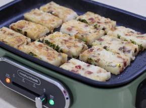 12.在不粘炒锅当中放入萝卜糕，煎制至双面金黄，即可盛起食用