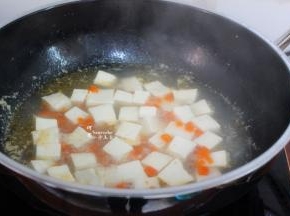 把豆腐放在手里，切小方块，然后放入锅里，再次煮沸。豆腐容易碎，切的时候放在手里切完直接入锅。