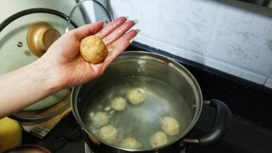 手粘上水将鸡胸肉泥搓圆，放入煮开的水里
