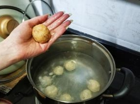 手粘上水将鸡胸肉泥搓圆，放入煮开的水里