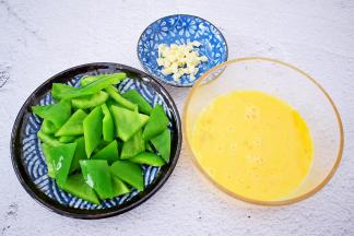 青椒去蒂去籽洗净切成小块，鸡蛋搅打均匀备用，蒜切末