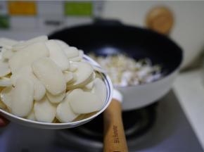 再将年糕片过水下锅，同时将细盐及料酒下锅，配炒至挂味。