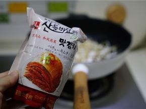 再将泡菜解开下锅，一同炒至年糕挂味就可以。