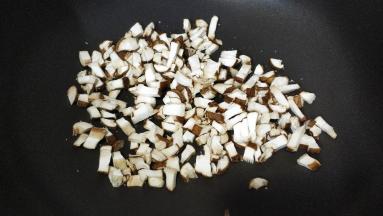 锅里热油，放入蒜盐、糖爆香后倒入鲜菇丁炒香