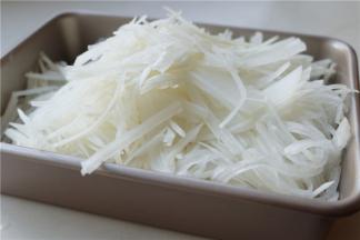 白萝卜一根，去掉根部和头部比较硬的部位，用擦丝器擦成细丝。萝卜丝的重量是600克。