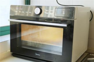 送入美的蒸烤箱，选择纯正模式，蒸1个小时。这款蒸烤箱是外置水箱，加满了可以蒸1个小时。蒸好的萝卜糕会蓬发一点，变得透明有光泽，出炉后会回缩。