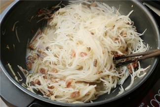 加入盐、白糖和120克水，煮一会至萝卜丝变软。