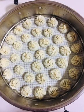 依次把所有的小笼包包好放进蒸锅的蒸屉上。