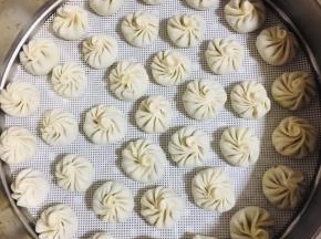 依次把所有的小笼包包好放进蒸锅的蒸屉上。