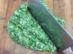 五花肉糜加入清洗干净的芹菜叶，放入一勺盐用刀剁成细细的肉馅儿。