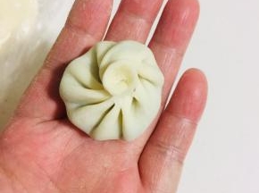 捏住一边，慢慢的向前捏出褶皱，最后收尾的时候捏紧旋转一下，一个漂亮的迷你小笼包就包好啦！