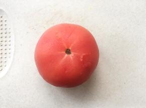 西红柿在表面划上2刀，放入锅内用热水烫一会，能脱去西红柿外皮即可
