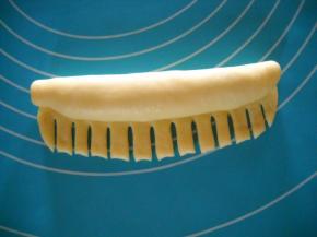 从一边卷起，留1/3处均匀剪成条状。