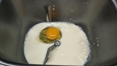 面包桶里放入牛奶、鸡蛋、蜂蜜拌均匀