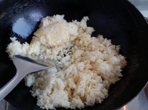 锅里放油下一半葱白和抓匀的米饭煸炒。