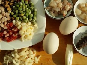 虾仁去沙线冲洗干净与鲜贝加料酒白胡椒一个蛋白抓匀备用。其他辅料切小丁备用。