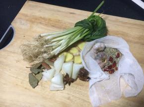 浸泡牛肉时准备佐料：小香葱打结、姜切片、洋葱切块，草果用到拍瘪，八角掰碎，香叶清洗干净、干辣椒和小茴香、蒜包在料包里。