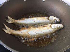 将鲢鱼的两面都蘸上薄薄的一层面粉，抖去多余的面粉，锅烧热后放入油（量大些），当油温5～6成热时放入鲢鱼。