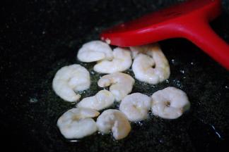 另起锅烧热后，把剩下的30克花生油烧热后倒入虾仁，小火慢慢进行翻炒。