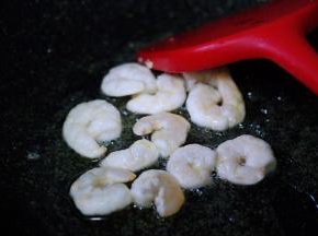 另起锅烧热后，把剩下的30克花生油烧热后倒入虾仁，小火慢慢进行翻炒。
