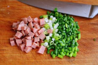 用刀把火腿肠切丁，小葱切碎，再把蒜薹用刀切成小丁。