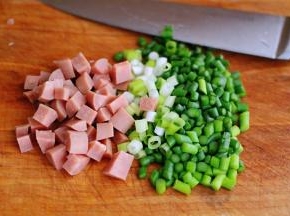 用刀把火腿肠切丁，小葱切碎，再把蒜薹用刀切成小丁。