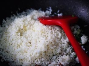 这时在锅中加入打散的米饭。