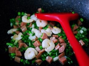 看见蒜薹断生变色的时候，加入切丁的火腿肠继续大火翻炒片刻。