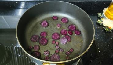 先用不粘锅放入少许蒜盐炒熟一点紫胡萝卜和鲜一数，让其水份先蒸发出来