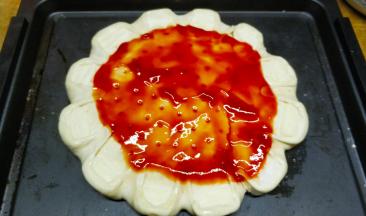 披萨饼底抹上番茄醬或披萨酱