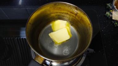 将称重好的黄油、水、糖、盐放入奶锅里，大火加热