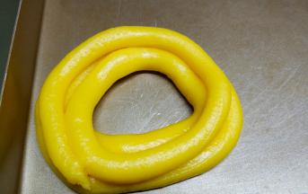 在不粘烤盘上画圆圈挤上面糊，挤上三层