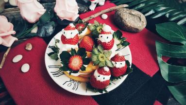 在表面上挤适量的奶油，放上草莓圣诞老爷爷