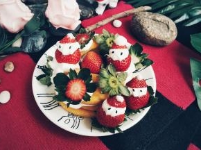 在表面上挤适量的奶油，放上草莓圣诞老爷爷