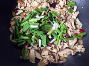 炒至香菇变色变软时加入蒜苗、适量生抽、盐翻炒均匀。