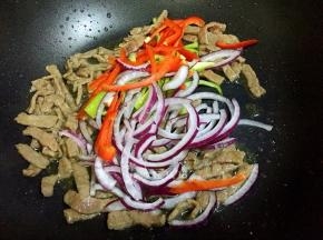 变色立即放入红椒、青椒和洋葱。