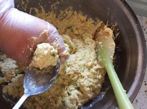 锅内放油，中火加热，至四成热，用手抓起一些拌好的丸子馅，用虎口挤出丸子，用勺子铲起