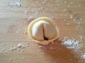 然后首位相连再捏紧，整一下形，一个漂亮的元宝饺子就包好了。