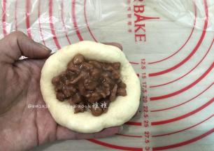 取一个松弛好的面团，擀开边上的气泡拍掉，翻面，码适量的叉烧肉