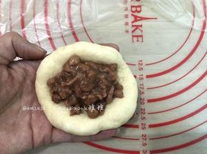取一个松弛好的面团，擀开边上的气泡拍掉，翻面，码适量的叉烧肉